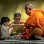 Jak przygotować ucznia do oceny: checklisty i kryteria, które zmniejszają lęk Mnich buddyjski rozmawia z dwojgiem dzieci siedzących na ziemi