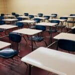 Matura międzynarodowa a polski system edukacji – co warto wiedzieć? Pusta sala lekcyjna z równo ustawionymi ławkami i krzesłami